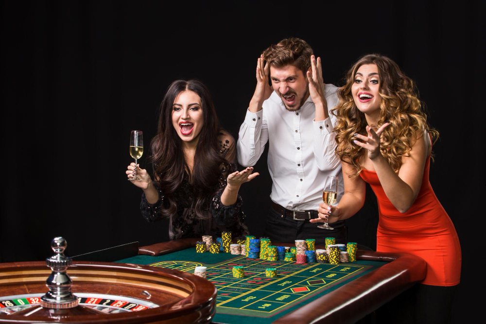 two young women man roulette table black background emotions players
