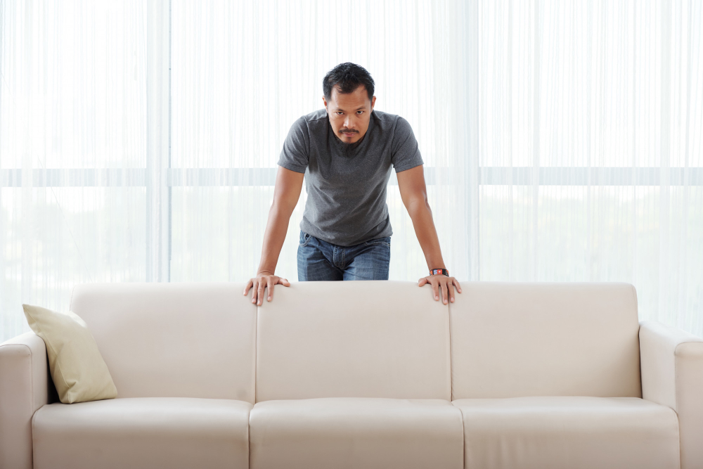 angry asian man standing couch leaning it looking camera 1